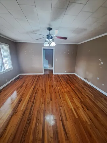 Rich hardwood flooring anchors this versatile space, ready for your custom updates.