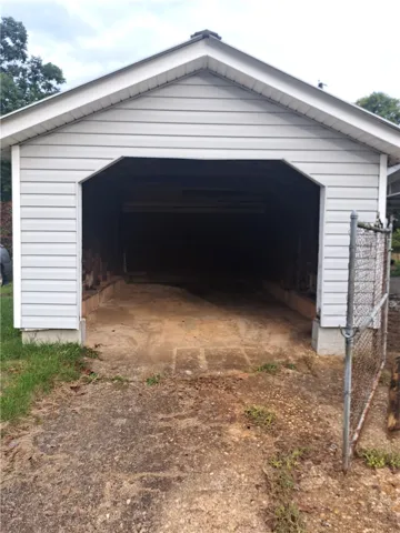 A detached single-car garage features durable vinyl siding and a solid concrete floor.