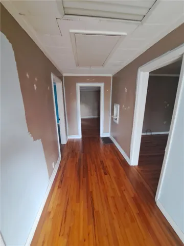 Gleaming hardwood floors guide you through the hallway connecting multiple rooms.