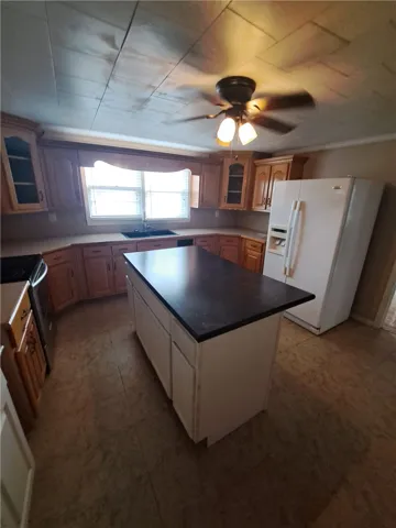 Rich wood cabinetry paired with a central prep island creates a functional kitchen layout.
