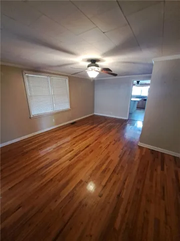 Warm hardwood floors anchor this inviting living space complete with crown molding.