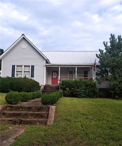 A welcoming front porch and classic metal roof highlight this charming single-story home.