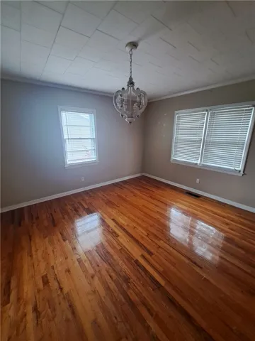 Polished hardwood flooring and abundant natural light define this versatile living space.