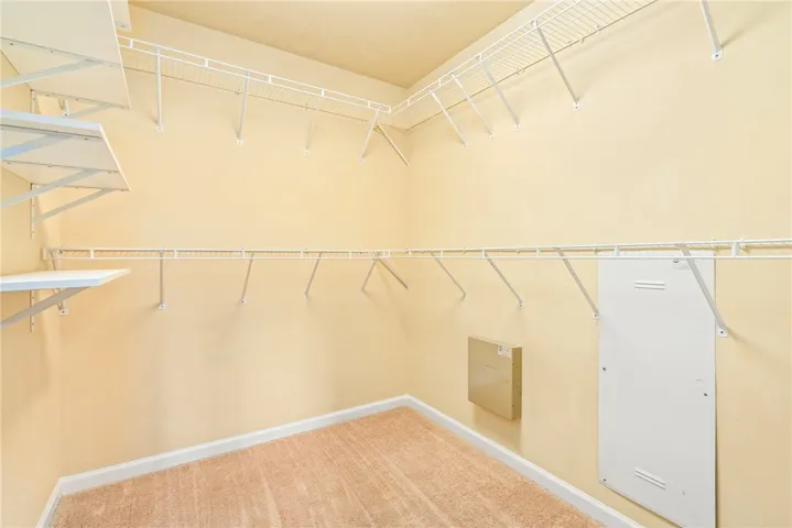 Ample wire shelving and soft carpeting define this functional walk-in closet space.