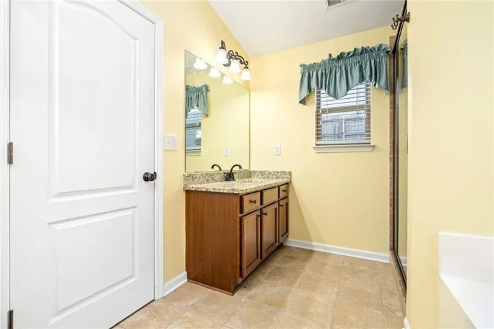 Tile flooring and a granite-topped vanity anchor this functional space.