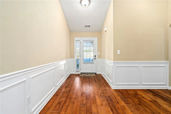 Rich hardwood flooring complements classic wainscoting lining this welcoming home entryway.