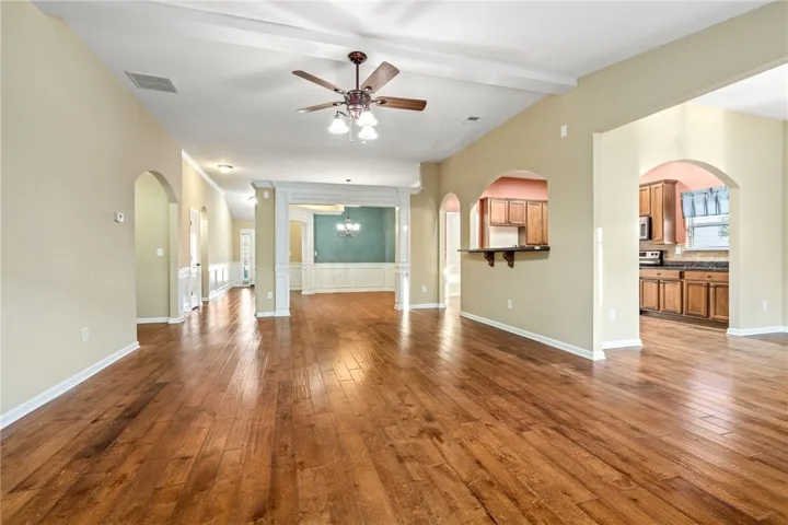 Gleaming hardwood floors flow throughout a spacious interior designed with elegant arched doorways.