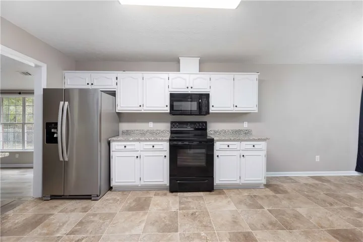 Granite countertops and clean white cabinetry anchor this functional culinary space.
