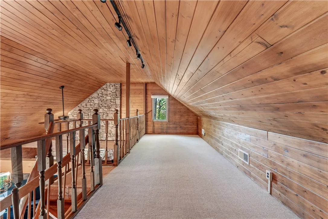 Rich wood planking lines the vaulted ceilings and walls of this charming loft space.