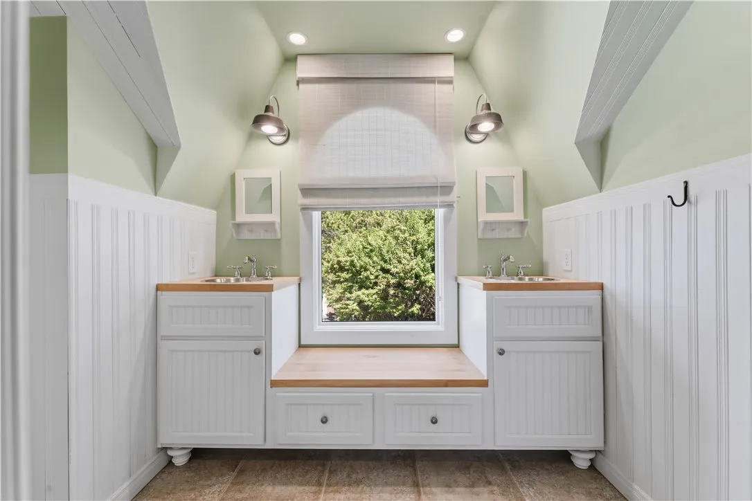 Sloped ceilings and a custom dual vanity create architectural character in this bright space.