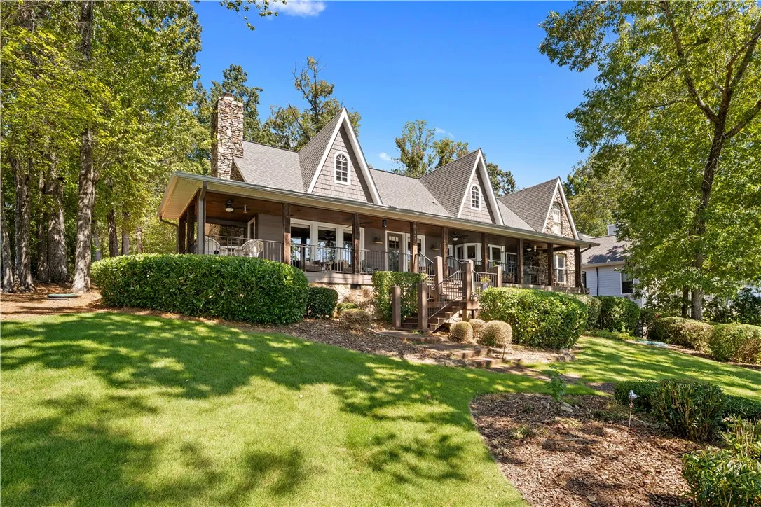 Gable rooflines and stone accents define this charming multi-level residence set against a wooded backdrop.