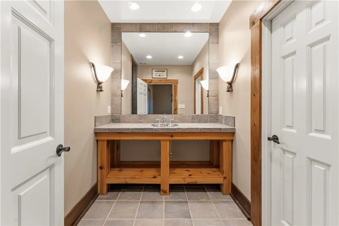 Natural wood accents and tile flooring create a rustic feel in this bathroom vanity area.