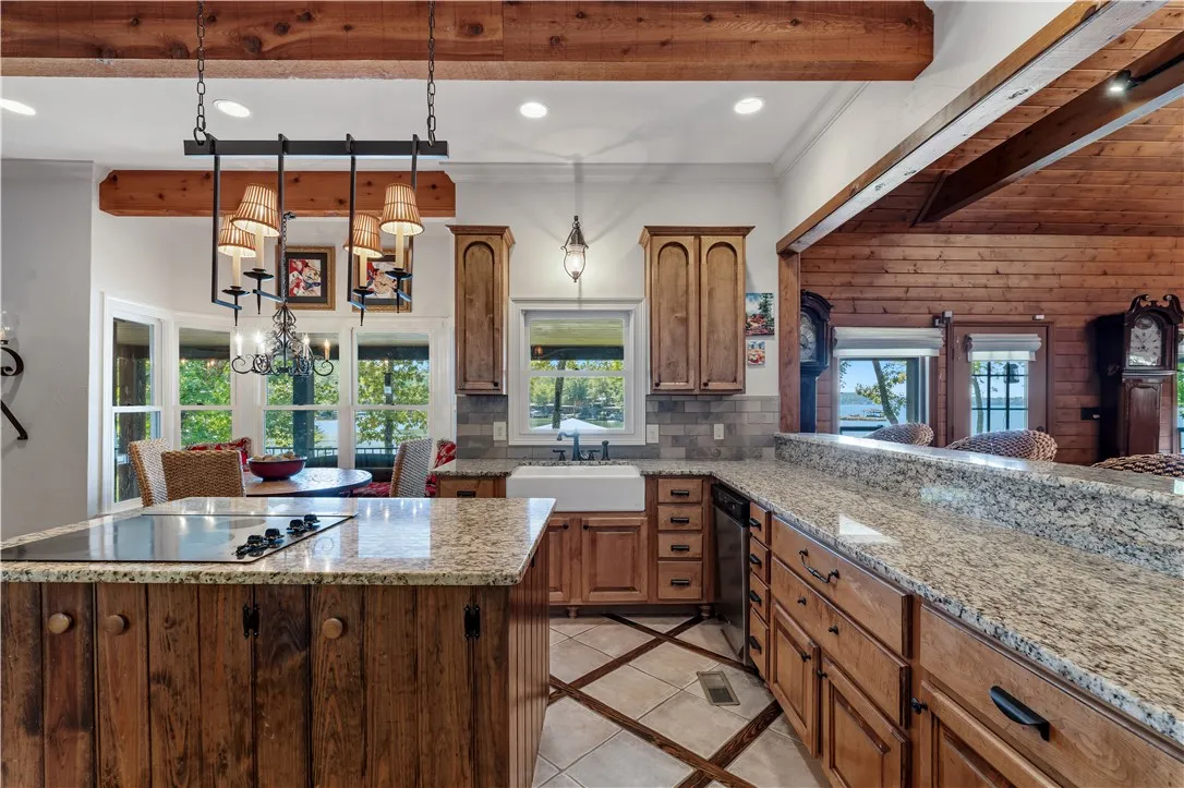 Rich wood beams and premium granite counters elevate this open-concept kitchen.