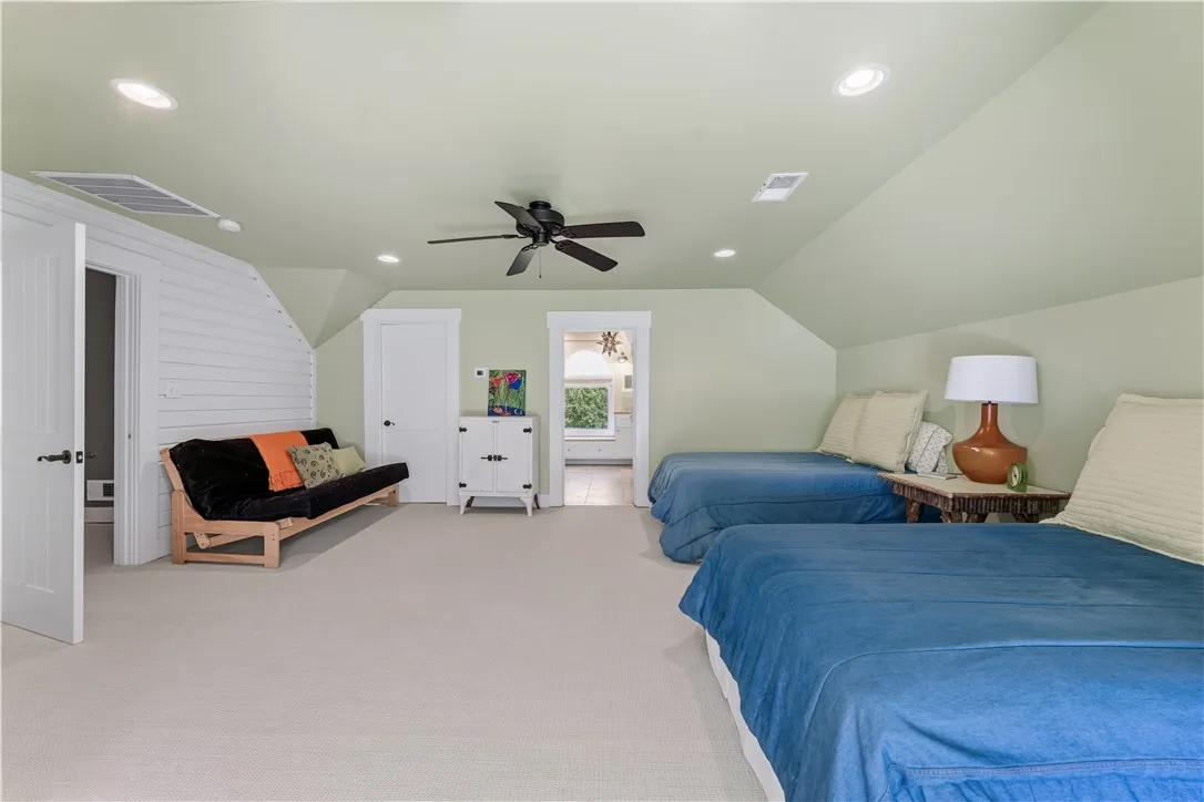 Angled ceilings and soft recessed lighting create a cozy feel throughout this bedroom.