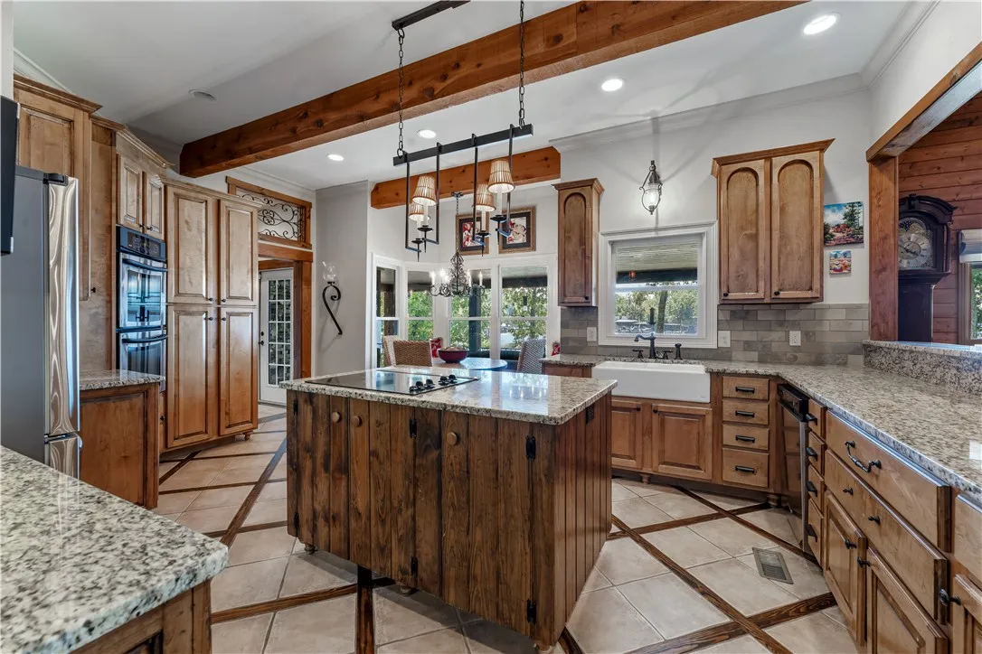 Rich wood beams span the ceiling of this culinary space with custom inlaid tile flooring.