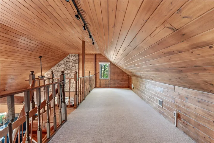 Rich wood planking lines the vaulted ceilings and walls of this charming loft space.