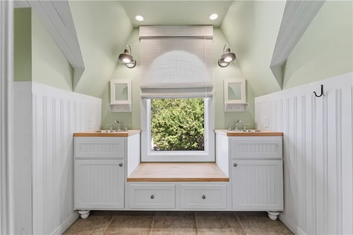 Sloped ceilings and a custom dual vanity create architectural character in this bright space.