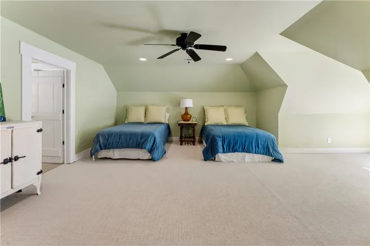 Angled ceilings and soft carpeting create a cozy, inviting atmosphere in this upper-level bedroom.