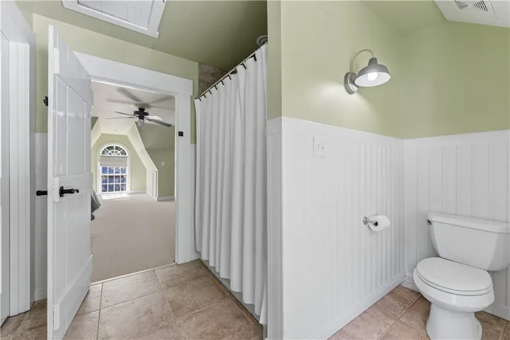 Classic wainscoting and durable tile flooring define this updated guest bathroom.