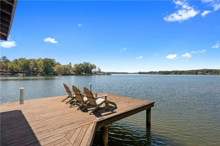 A spacious wooden dock projects over peaceful waters, showcasing expansive lakefront views.