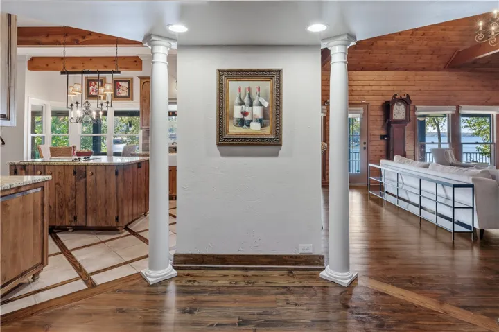 Gleaming hardwood floors and classic architectural columns frame views of the rustic, light-filled interiors.