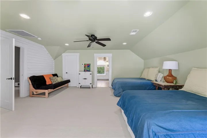 Angled ceilings and soft recessed lighting create a cozy feel throughout this bedroom.