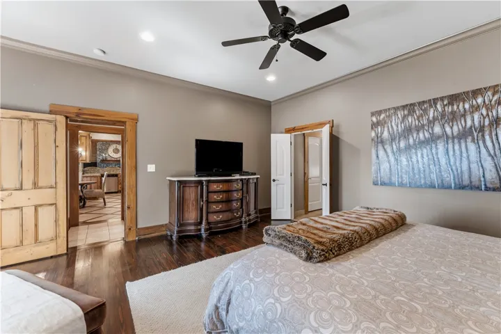 Rich hardwood floors and classic crown molding elevate this serene bedroom space.