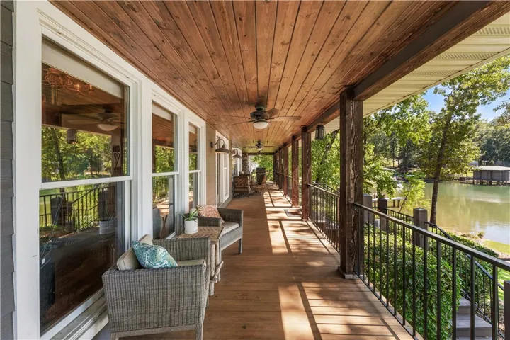 A spacious covered deck features a warm wood ceiling and overlooking serene waterfront views.