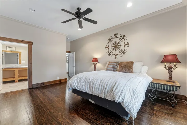 Rich hardwood floors and elegant crown molding define this serene main-level bedroom suite.