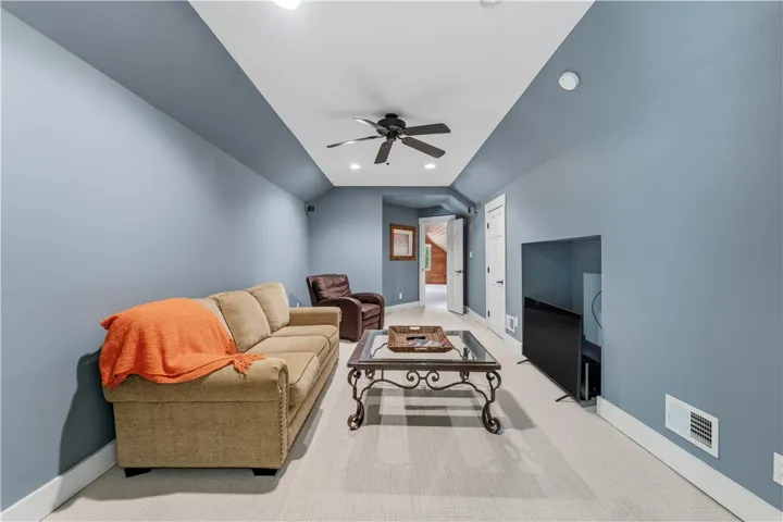 A long, versatile bonus room features clean baseboards and recess lighting along vaulted ceiling lines.
