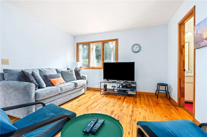 Warm hardwood floors and classic wood-framed windows anchor this comfortable living space.