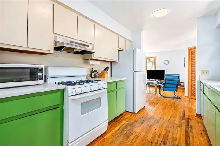 Rich hardwood flooring anchors the functional kitchen layout opening directly to adjacent living spaces.