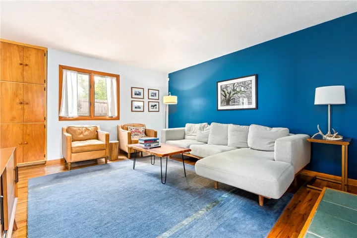 Gleaming hardwood floors and a generous wood casement window define this comfortable living space.