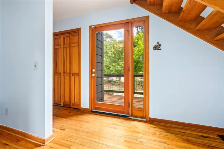 Warm hardwood flooring and natural wood doors welcome you into this inviting entry space.