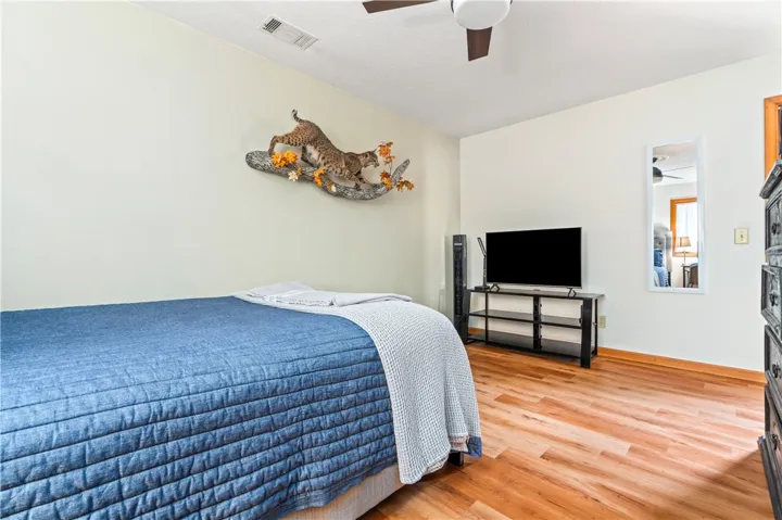 Warm wood flooring and smooth plaster walls define this comfortable bedroom space.
