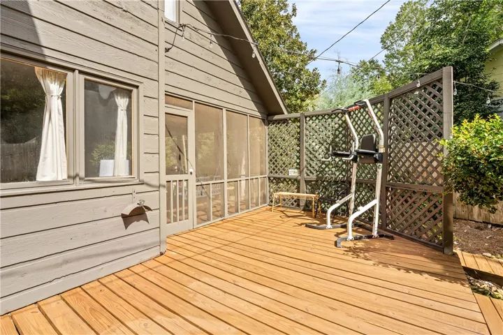 A spacious wooden deck extends alongside the house, bordered by privacy lattice fencing.