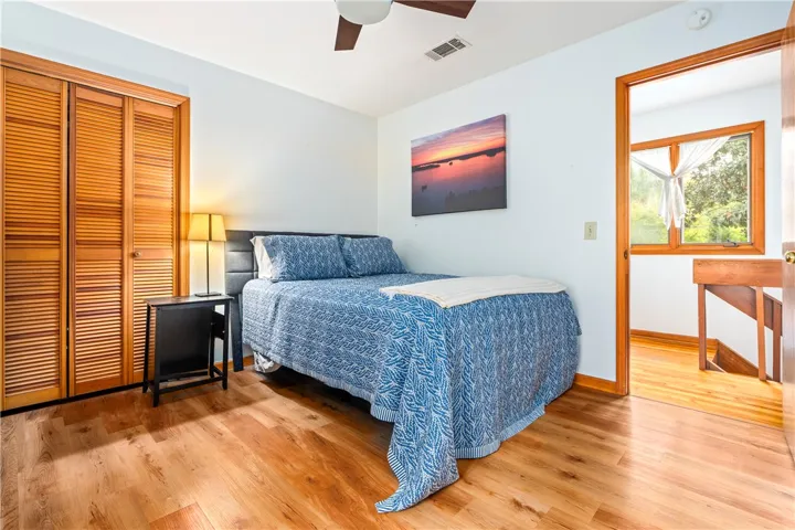 Rich hardwood floors complement the natural wood trim and closet doors in this upper-level bedroom.