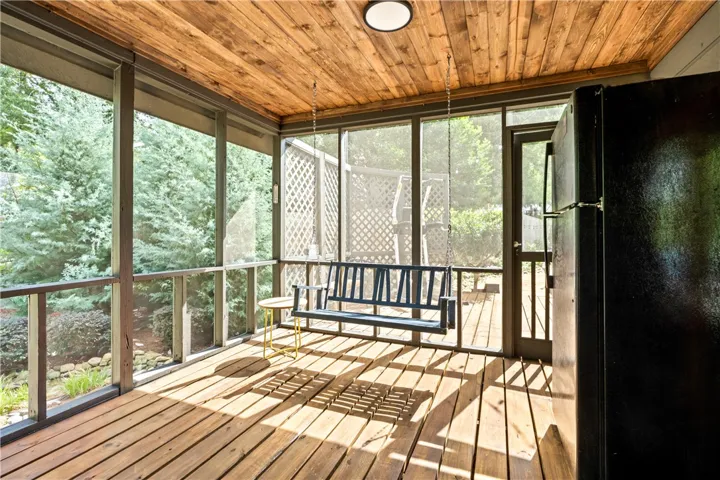 Rich wood plank ceilings and flooring bring natural warmth to this screened porch.