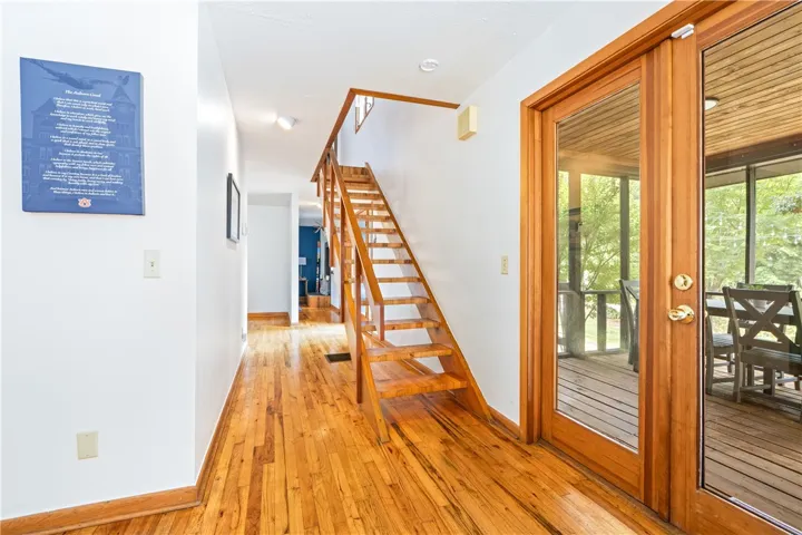Gleaming hardwood floors and a modern open-riser staircase anchor this welcoming home entrance.