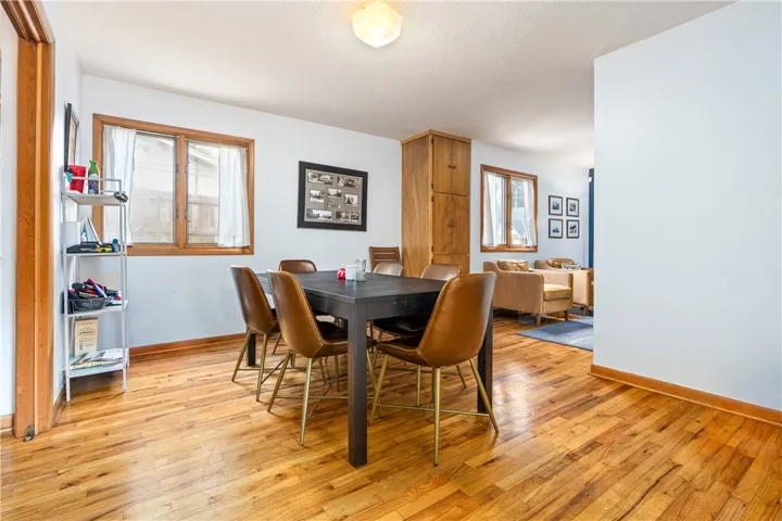 Rich hardwood floors flow through this dining area equipped with classic wood window frames.