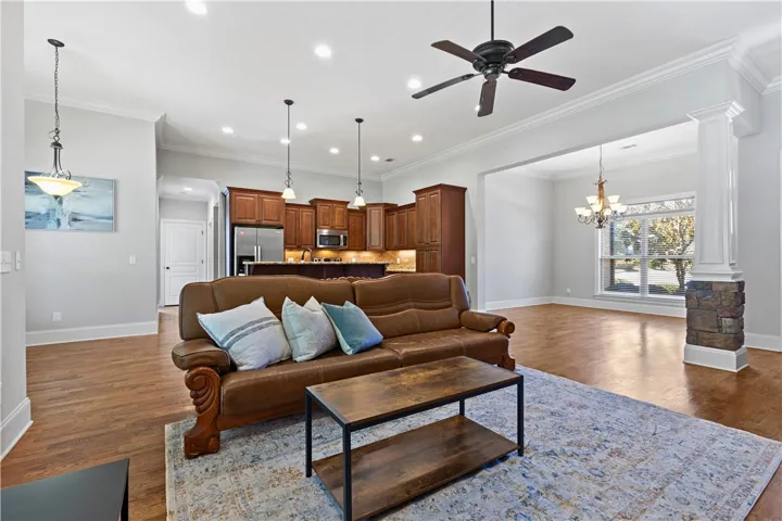 Polished hardwood floors and elegant crown molding define this open, airy living space.