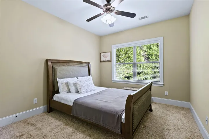 Warm carpeting pairs with a classic multi-pane window in this cozy and comfortable bedroom.