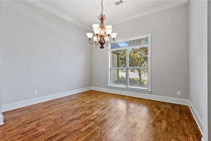 Gleaming hardwood floors and classic crown molding define this versatile dining space.