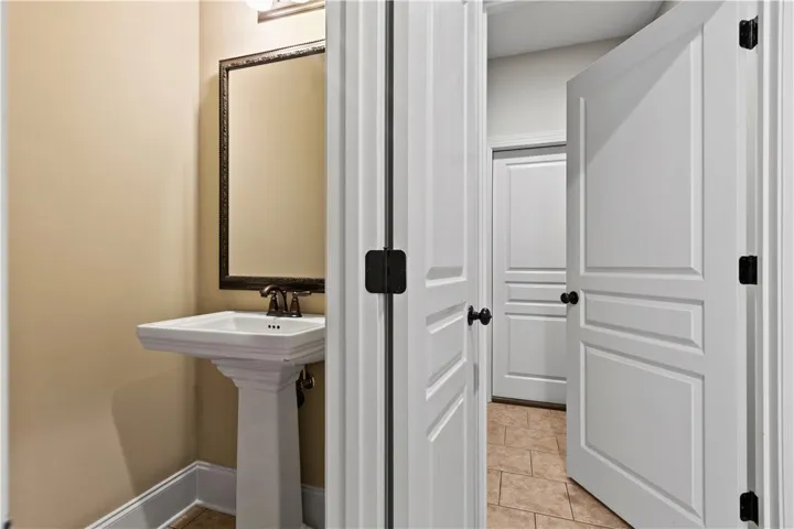 A classic pedestal sink and framed mirror create an elegant and functional powder room.