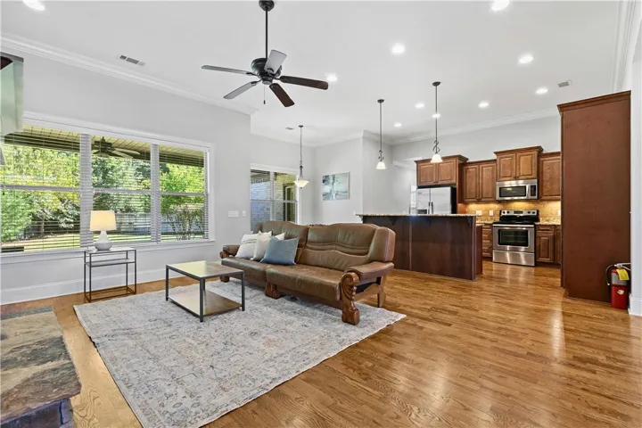 Rich hardwood floors sweep through this airy, open-concept living area and kitchen space.