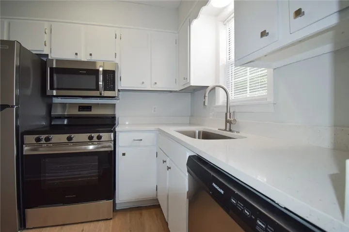 Crisp white cabinetry pairs perfectly with durable solid-surface countertops in this updated space.