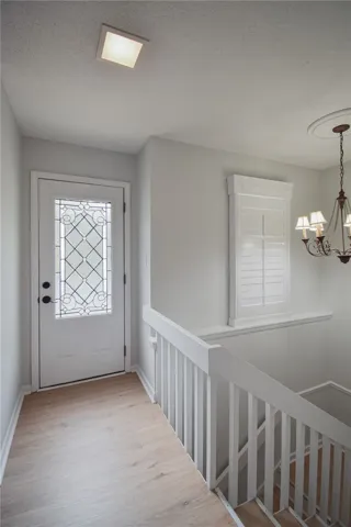 Gleaming wood floors and an elegant glass-inset door define this welcoming entryway.