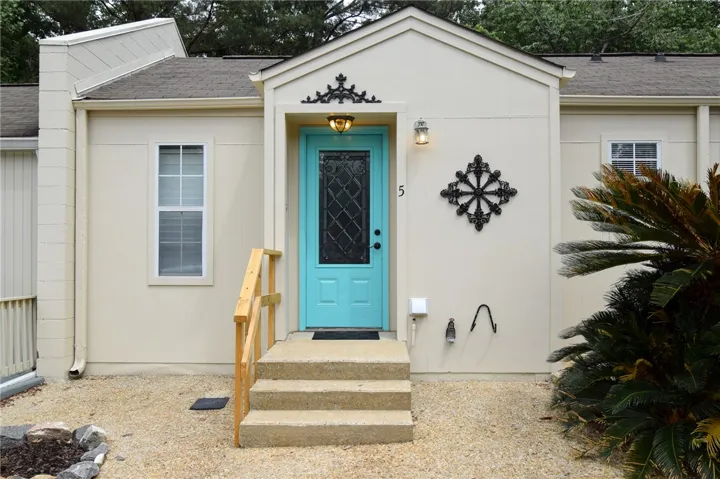 Concrete steps ascend to a welcoming entry with an ornamental front door.