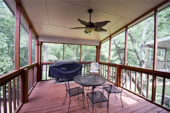Mature woodlands frame the views from this screened porch featuring rich wood decking.