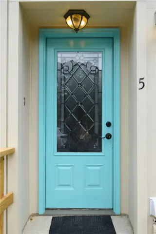 A welcoming entryway features a bright door accented by leaded glass paneling.